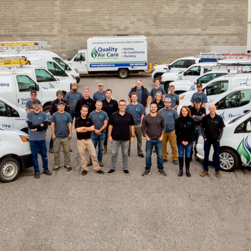 Quality Air Care team standing with the company fleet in Kelowna