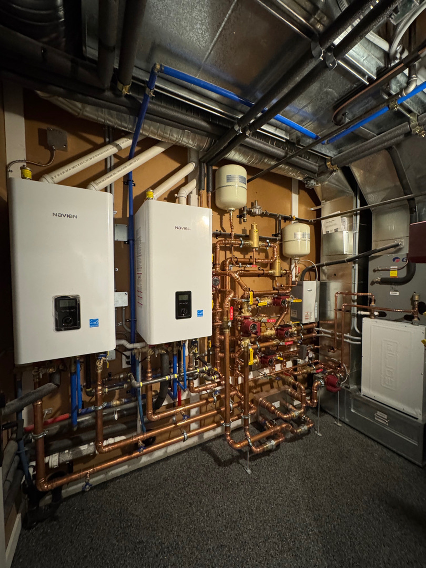 Twin combi boiler plant with copper piping in a mechanical room