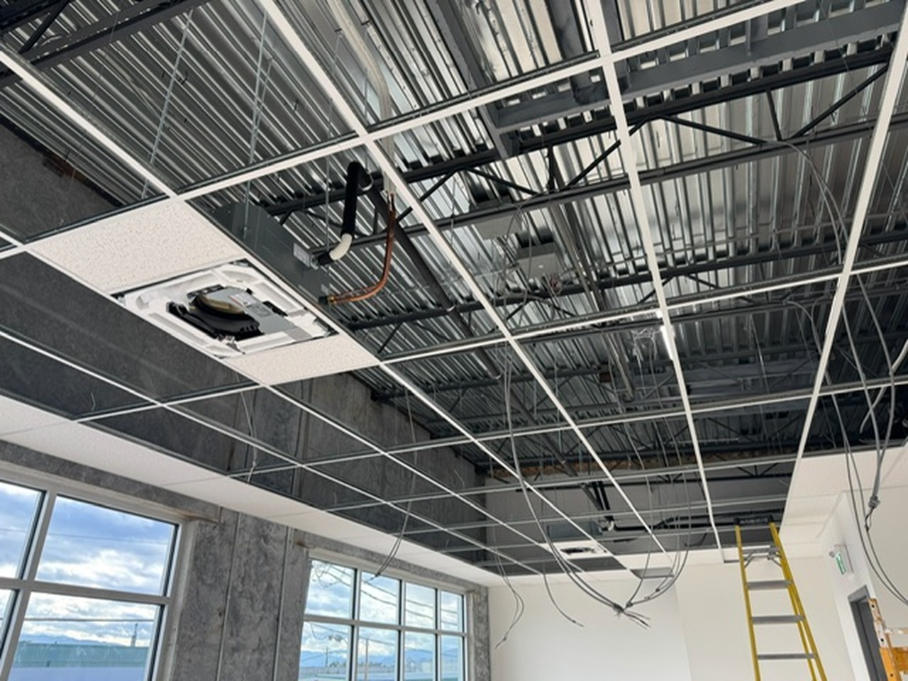 Ceiling cassette and refrigerant lines installed above a suspended ceiling grid