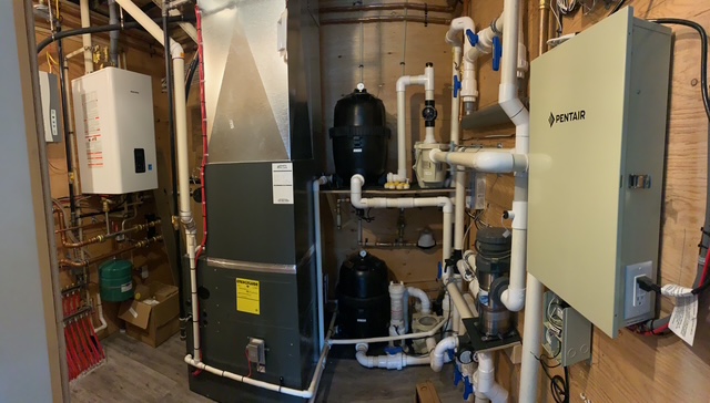 Air handler, boiler, pumps and controls in a residential mechanical room