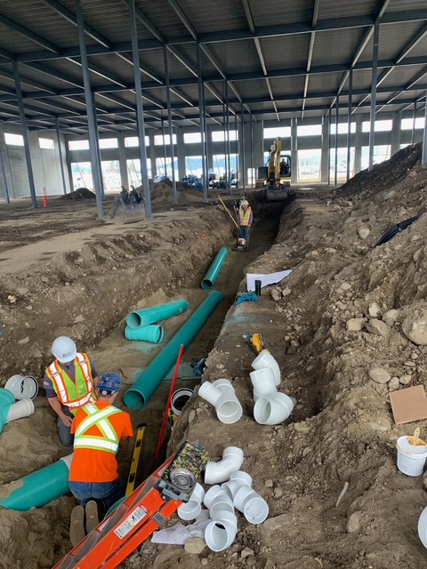 Quality Air Care crew installing commercial plumbing mains inside a building