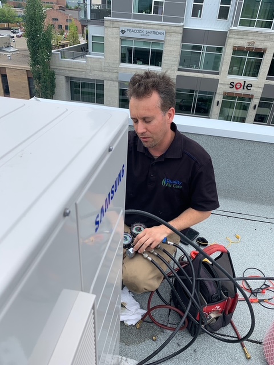 Quality Air Care technician servicing rooftop HVAC equipment