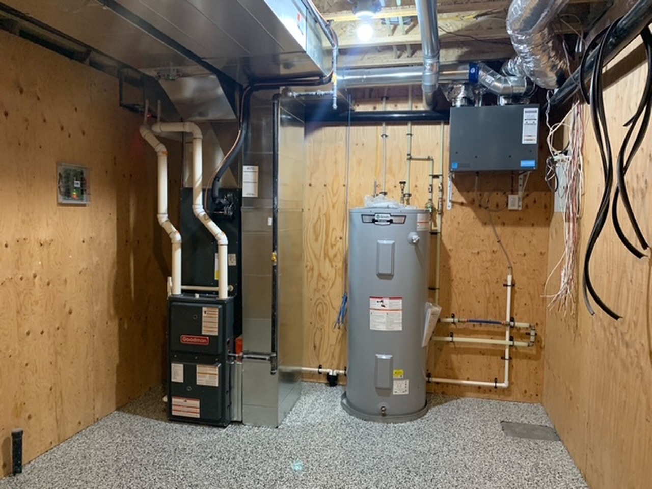 Furnace and hot water tank installed together in a residential mechanical room